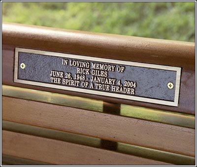 Photo of plaque on Crocker Park bench with inscription that states, " In loving memory of Rick Giles, June 26, 1948 – January 4, 2004. The Spirit of a True Header."